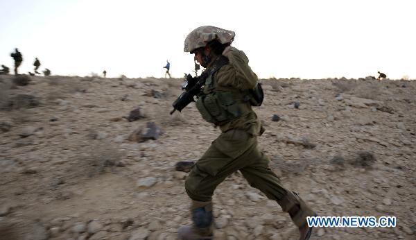 A female Israeli Defense Force (IDF) soldier takes part in a drill in desert near Israel-Egypt border and Israeli Southern City of Sede Boker, on Dec.13, 2010. 