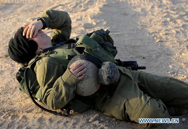 A female Israeli Defense Force (IDF) soldier rests during a drill in desert near Israel-Egypt border and Israeli Southern City of Sede Boker, on Dec.13, 2010. 