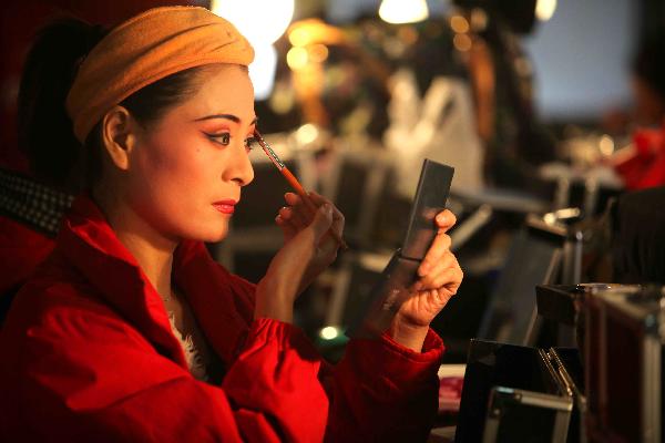 An actress puts on face-painting before staging a repertoire of Shaoxing Opera in Tongpu Village of Rui'an City, east China's Zhejiang Province, Dec. 13, 2010. 