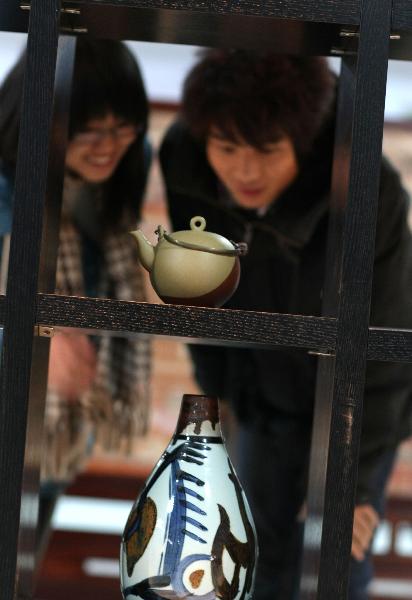 Visitors admire artworks displayed at a folk art show held in Nantong Textile Vocational College in Nantong, east China's Jiangsu Province, Dec. 14, 2010.