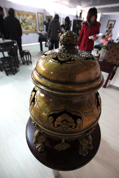 A copper stove is seen at a folk art show held in Nantong Textile Vocational College in Nantong, east China's Jiangsu Province, Dec. 14, 2010. 