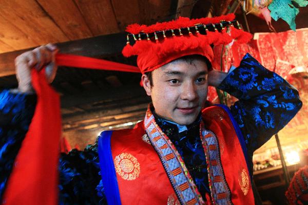 A young man dresses up for the debutant for young men of Yao ethnic group in Gaodian Village of Rongshui Miao Autonomous County, south China's Guangxi Zhuang Autonomous Region, Dec. 12, 2010. 