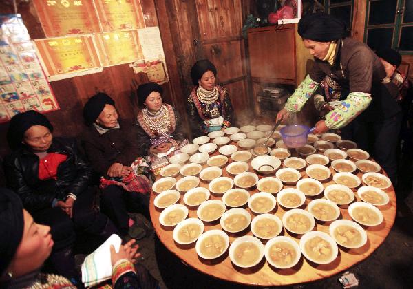 Women of Yao ethnic group prepare beancurd wine at the debutant for young men of Yao ethnic group in Gaodian Village of Rongshui Miao Autonomous County, south China's Guangxi Zhuang Autonomous Region, Dec. 13, 2010. 
