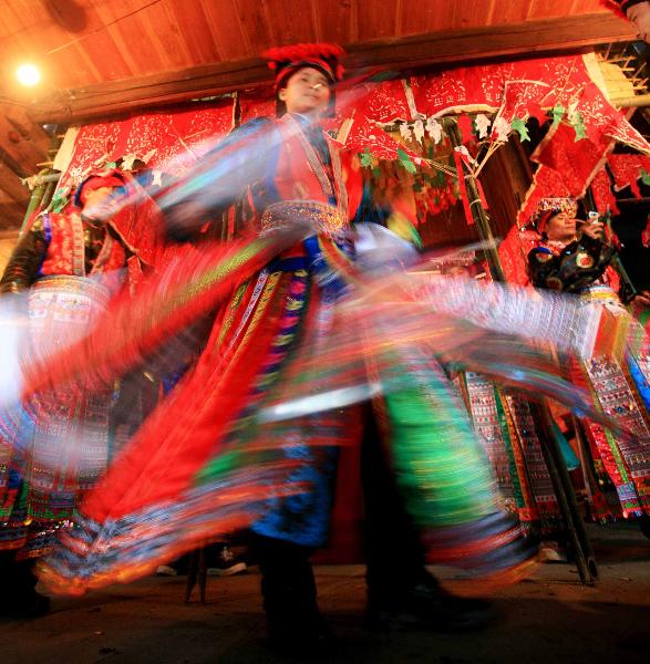 Young men dance at the debutant for young men of Yao ethnic group in Gaodian Village of Rongshui Miao Autonomous County, south China's Guangxi Zhuang Autonomous Region, Dec. 12, 2010. 