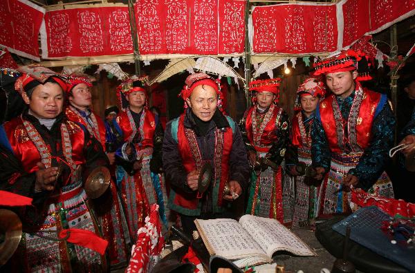 A teacher(C) leads young men to chant lection at the debutant for young men of Yao ethnic group in Gaodian Village of Rongshui Miao Autonomous County, south China's Guangxi Zhuang Autonomous Region, Dec. 12, 2010.
