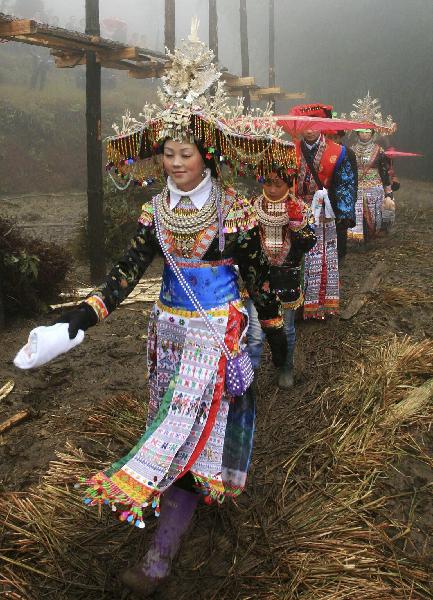 A woman of Yao ethnic group participates in parade during the debutant for young men of Yao ethnic group in Gaodian Village of Rongshui Miao Autonomous County, south China's Guangxi Zhuang Autonomous Region, Dec. 13, 2010. 