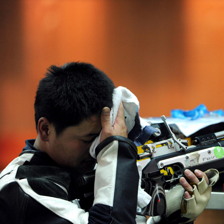 Tian Fugang wipes the sweat away in R1-SH1 men's 10m air rifle standing shooting event at the 2010 Asian Para Games in Guangzhou, Dec 13, 2010. 