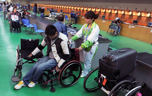 Tian Fugang changes his wheelchair after the first day's qualification round for R1-SH1 men's 10m air rifle standing shooting event at the 2010 Asian Para Games in Guangzhou, Dec 13, 2010.