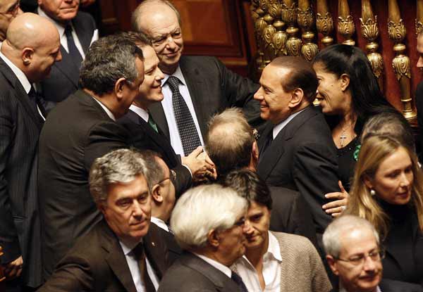Italian Prime Minister Silvio Berlusconi (C) leaves after a session at the Senate in Rome December 14, 2010. [Xinhua]