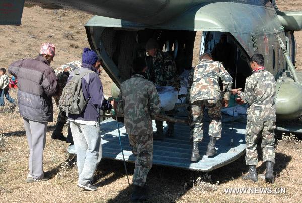 This hand out picture provided by Nepalese Army on 16 December 2010 shows Nepalese soldiers carrying the remains of a victim killed in a Tara Air domestic flight near the crash site in the Okhaldunga district, east of Kathmandu capital of Nepal. 