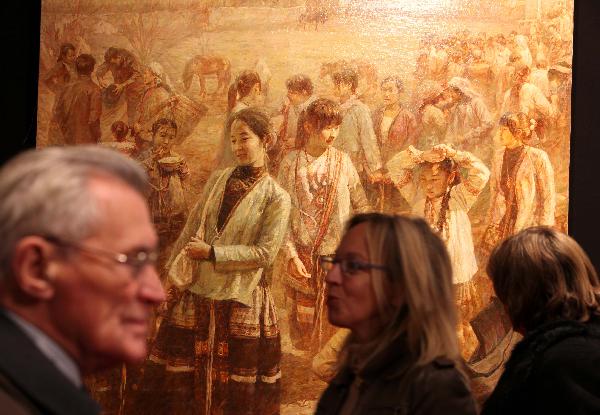People look at Chinese artists' paintings during the Salon 2010 held by the French National Society of Fine Arts at Carrousel in the Louvre Palace in Paris, capital of France, Dec. 16, 2010.