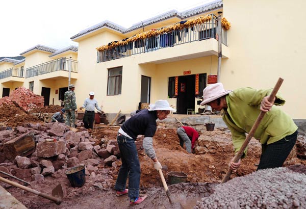 Local farmers build kitchens and washing rooms near their welfare houses built after an earthquake in Yao'an, Yunnan Province, Dec 9, 2010.