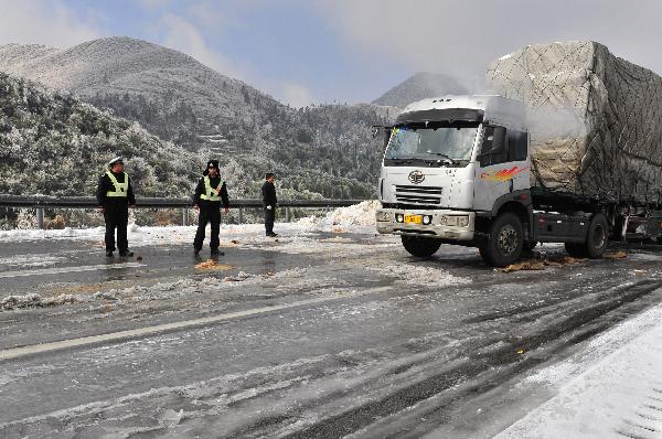 A truck moves under the direction of traffic police on the frozen G4 expressway linking Beijing, Hong Kong and Macao in the section within south China&apos;s Guangdong Province, Dec. 16, 2010.