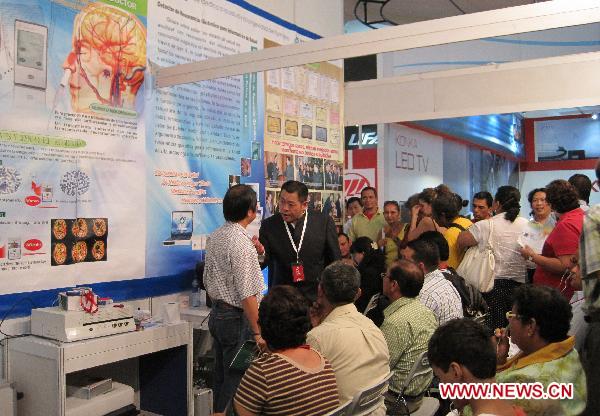 A staff member (C) of a Chinese medical equipment company introduces health knowledges to local residents at the 2010 Chinese Trade Fair in Managua, capital of Nicaragua, Dec. 17, 2010. 