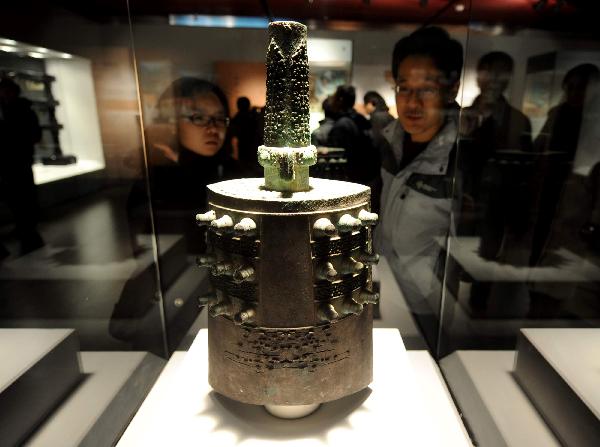 Visitors look at an ancient bell of the Spring and Autumn Period (770 B.C.-476 B.C.) at the exhibition hall in the National Center For the Performing Arts in Beijing, capital of China, Dec. 20, 2010. 
