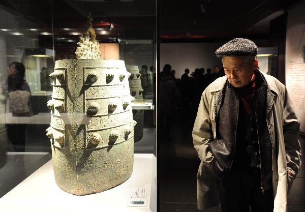 A visitor walks past bricks carved with images of artists at the exhibition hall in the National Center For the Performing Arts in Beijing, capital of China, Dec. 20, 2010. 