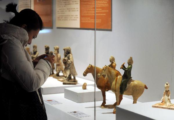 A visitor takes pictures of sculptures of musicians that dates back to Tang Dynasty (618-907 A.D.) at the exhibition hall in the National Center For the Performing Arts in Beijing, capital of China, Dec. 20, 2010. 