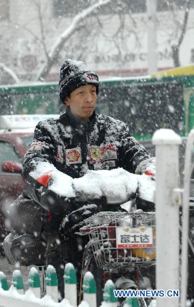 A man rides against snow in Urumqi, capital of northwest China&apos;s Xinjiang Uygur Autonomous Region, Dec. 21, 2010. 