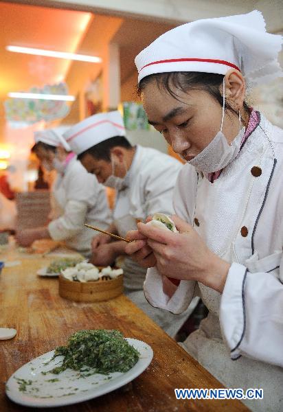 Staff members of a restaurant makes dumplings in Yinchuan, capital of northwest China&apos;s Ningxia Hui Autonomous Region, Dec. 21, 2010. 