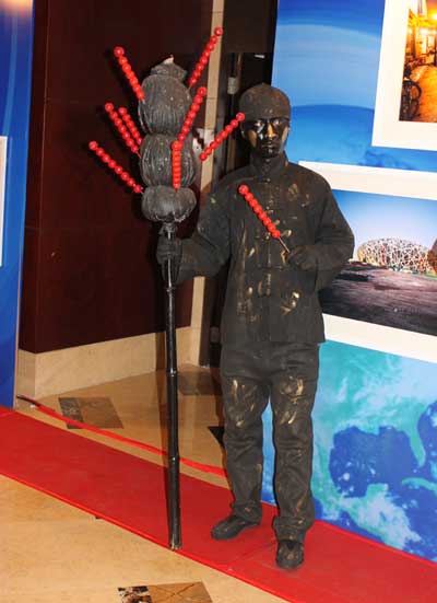 A man was dressed as a bronze statue selling sugarcoated hawthorns on a stick, a traditional Beijing snack. 