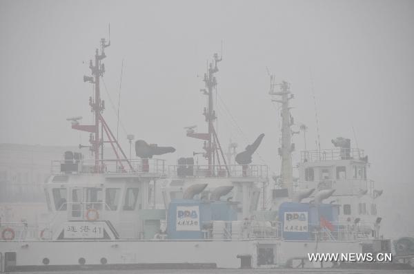 Ships rest at anchor in fog-shrouded Dalian, northeast China's Liaoning Province, Dec. 22, 2010. 
