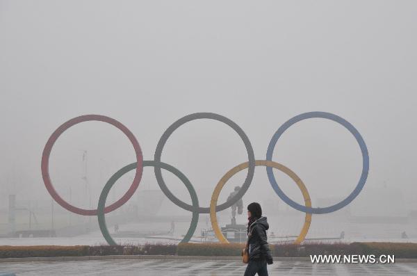 A resident walks past an inner city square in fog-shrouded Dalian, northeast China's Liaoning Province, Dec. 22, 2010. 