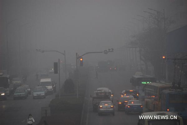 Vehicles travel on the road in fog-shrouded Dalian, northeast China's Liaoning Province, Dec. 22, 2010. Heavy fog hit Dalian Wednesday morning, disrupting the traffic in the coast city as visibility was reduced to less than 50 meters. 