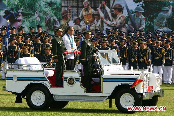 Philippine President Benigno Aquino III (C) stands on a vehicle as he inspects the troops during the celebration of the 75th founding anniversary of the Armed Forces of the Philippines at Camp Aguinaldo in Quezon City, Dec. 21, 2010.