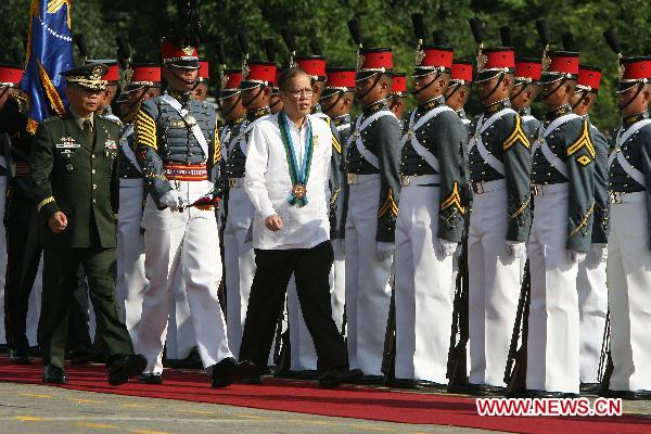 Philippine President Benigno Aquino III (Front R) inspects the troops during the celebration of the 75th founding anniversary of the Armed Forces of the Philippines at Camp Aguinaldo in Quezon City, Dec. 21, 2010.