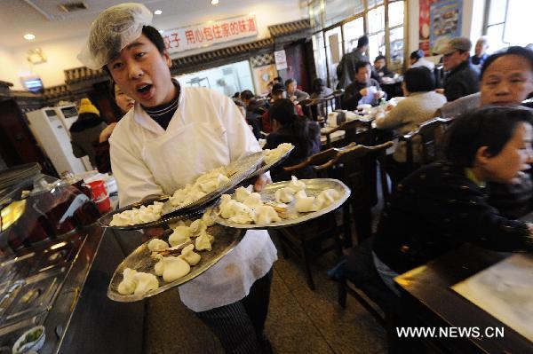 A waiter serves dumplings for customers at a restaurant in Beijing, capital of China, Dec. 22, 2010, also the day of Dongzhi, the traditional Chinese winter solstice festival. 