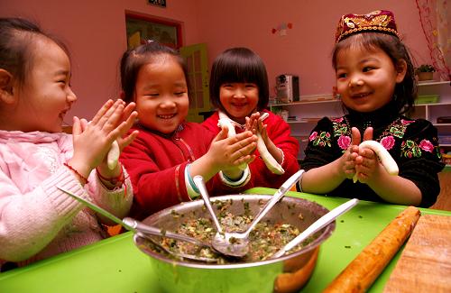 Children make dumplings at a kindergarten in Hami, northwest China's Xinjiang Uygur Autonomous Region, Dec 21, 2010.