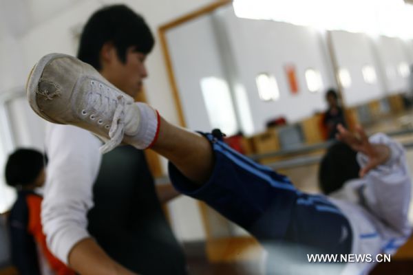 May Thinzar from Myanmar practises basic motions of acrobatics at Wuqiao acrobatic art school in Wuqiao County, north China's Hebei Province, Dec. 23, 2010. 
