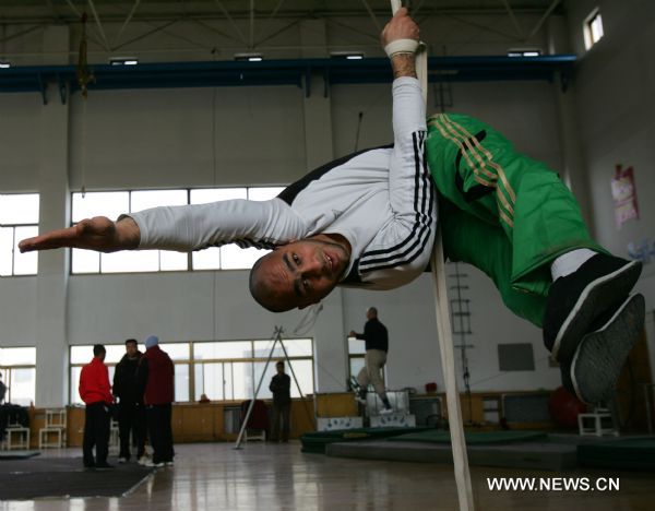 Belal from Egypt practises basic motions of acrobatics at Wuqiao acrobatic art school in Wuqiao County, north China's Hebei Province, Dec. 23, 2010.