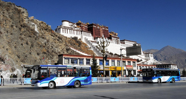 Two new buses run in front of the Potala Palace in Lhasa, capital of the Tibet Autonomous Region on Dec 26, 2010. 