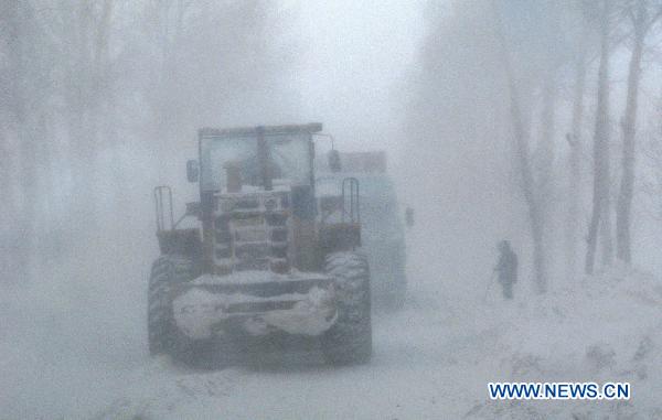 Workers clean the snow blocking the express way connecting Yilan and Boli in northeast China's Heilongjiang Province, Dec. 25, 2010.