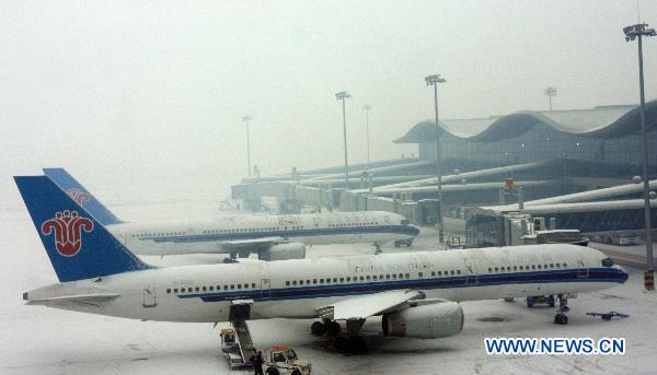 Planes are parked on the snow-covered tarmac at Urumqi International Airport in Urumqi, capital of northwest China's Xinjiang Uygur Autonomous Region, Dec. 26, 2010. Heavy snow attacked Urumqi Saturday and caused flights delayed at airport.