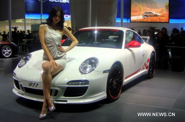 A model promotes a Porsche at the 8th China Guangzhou International Automobile Exhibition in Guangzhou, capital of south China's Guangdong Province, Dec. 27, 2010.