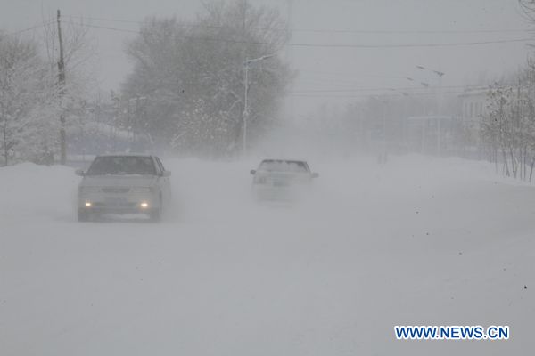Vehicles move slowly in heavy snow, on a national highway in Altay, northwest China's Xinjiang Uygur Autonomous Region, Dec. 27, 2010. 