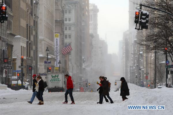 People walk on the snow-covered street in Manhattan of New York, the United States, Dec. 27, 2010. 