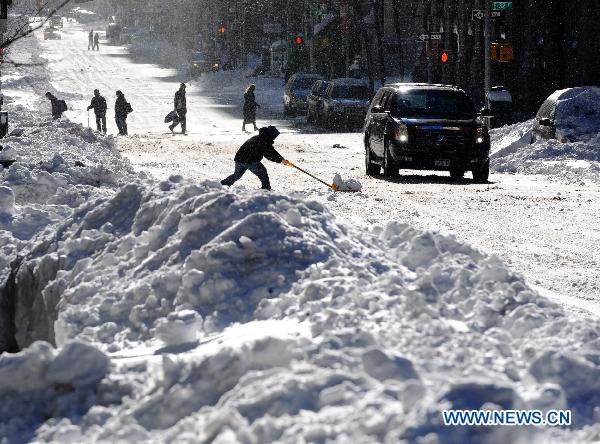 People make their way on the snow-covered street in Manhattan of New York, the United States, Dec. 27, 2010. 