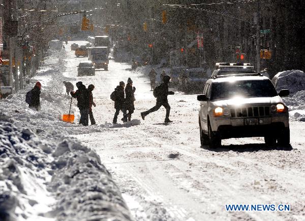 People make their way on the snow-covered street in Manhattan of New York, the United States, Dec. 27, 2010.