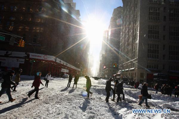 People walk on the snow-covered street in Manhattan of New York, the United States, Dec. 27, 2010.