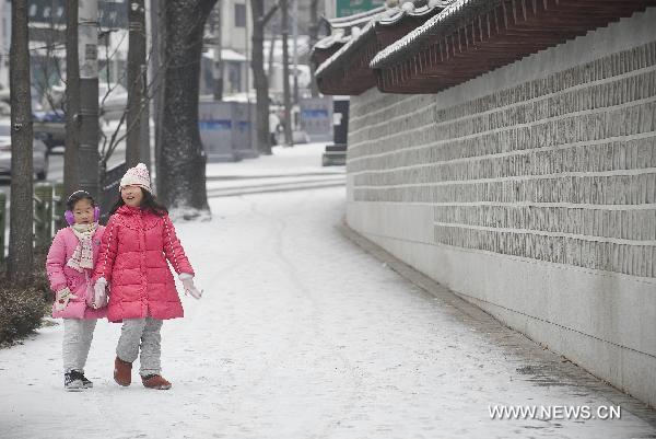Two girls walk in snow-coated street in Seoul, Dec. 27, 2010.