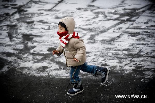 A kid runs in snow-coated street in Seoul, Dec. 27, 2010.