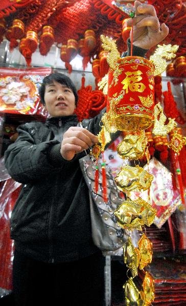 A woman presents a tiny red lantern she purchased in a shopping mall in Yinchuan, capital of northwest China's Ningxia Hui Autonomous Region, Dec. 28, 2010.