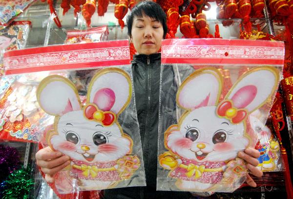A woman presents a rabbit-patterned wallpaper she purchased in a shopping mall in Yinchuan, capital of northwest China's Ningxia Hui Autonomous Region, Dec. 28, 2010.