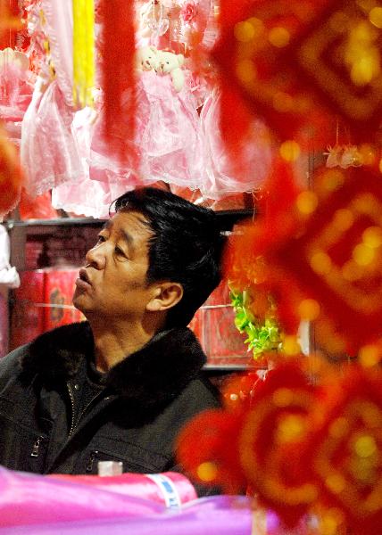 A man chooses new year decorations in a shopping mall in Yinchuan, capital of northwest China's Ningxia Hui Autonomous Region, Dec. 28, 2010. 