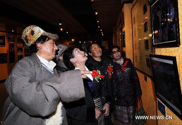 Artists visit a photo exhibition during a celebration to mark the 50th anniversary of the founding of Tibetan Opera Troupe in Lhasa, capital of southwest China's Tibet Autonomous Region, Dec. 28, 2010. 