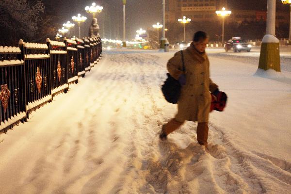 A pedestrian walks on the snow covered sidewalk in Urumqi, northwest China's Xinjiang Uygur Autonomous Region, Dec. 28, 2010. 
