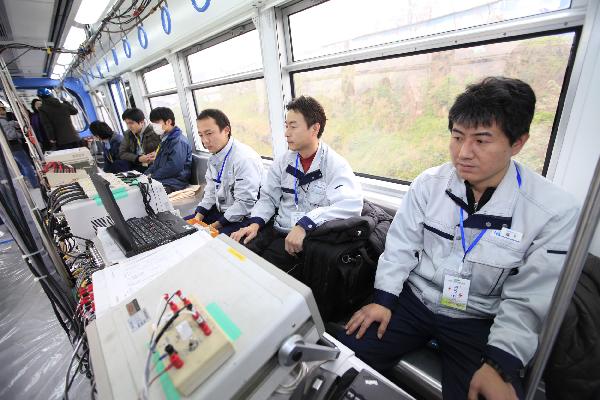 Workers test on a trial train of Chongqing Subway Line No.3 in southwest China&apos;s Chongqing Municipality, Dec. 28, 2010.